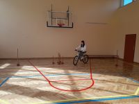 Uczennica jedzie na rowerze po torze przeszkód